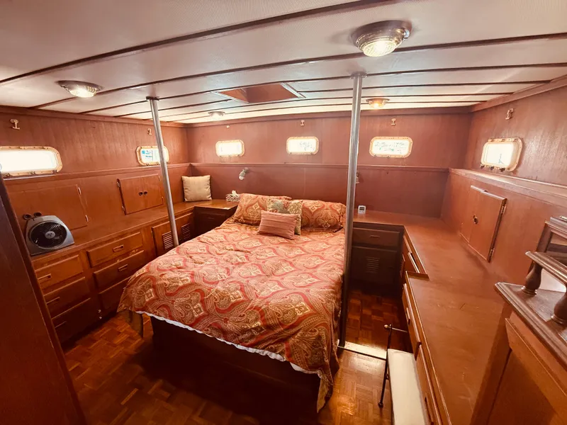 Slide: The Image of Luxurious 1980 C & L Sea Ranger yacht cabin with wood paneling and cozy bedding. - 19