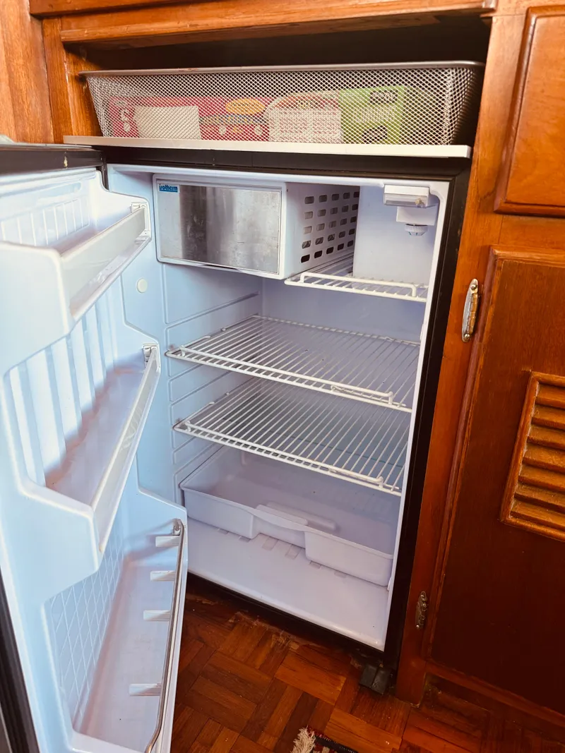 Slide: The Image of Empty refrigerator inside a 1980 C & L Sea Ranger boat. - 29