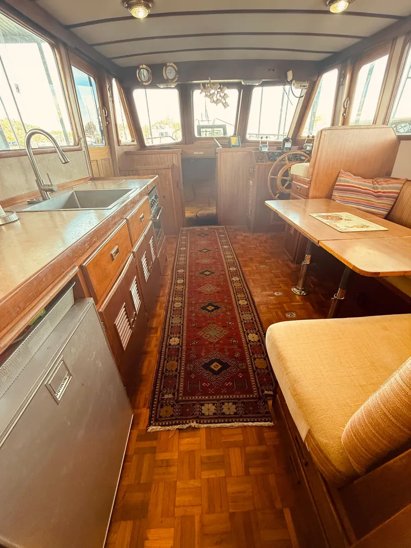 Slide: The Image of Interior of a 1980 C & L Sea Ranger boat with wood finishes and a cozy dining area. - 32