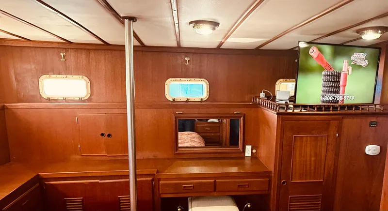 Slide: The Image of 1980 C & L Sea Ranger interior with wood paneling, portholes, and a TV. - 35