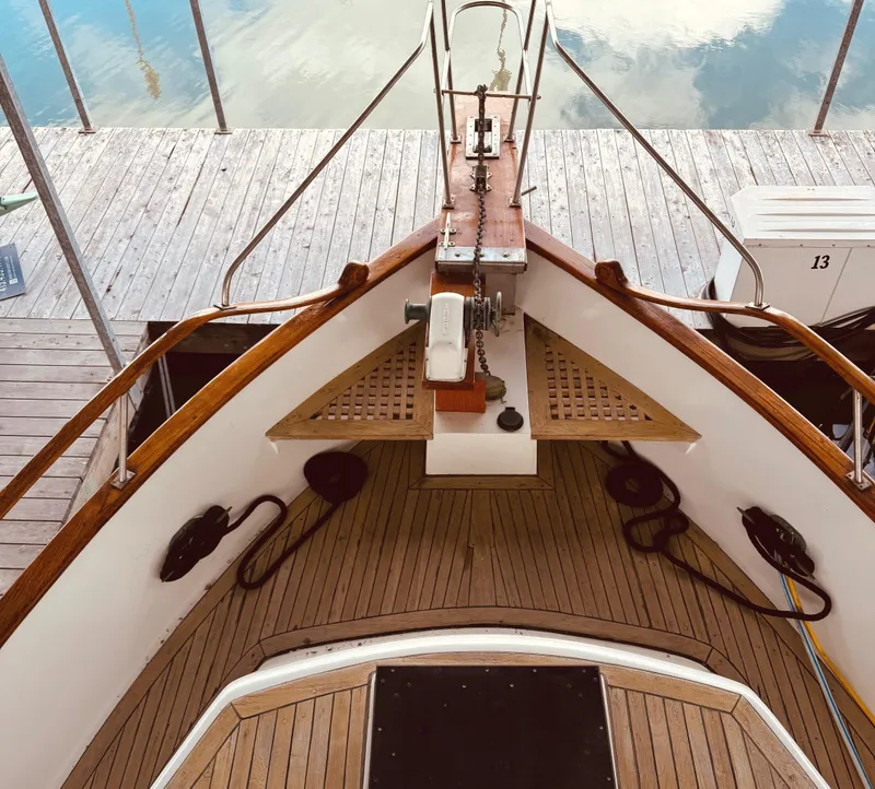 Slide: The Image of 1980 C & L Sea Ranger boat deck with wooden finish, docked at a marina. - 4