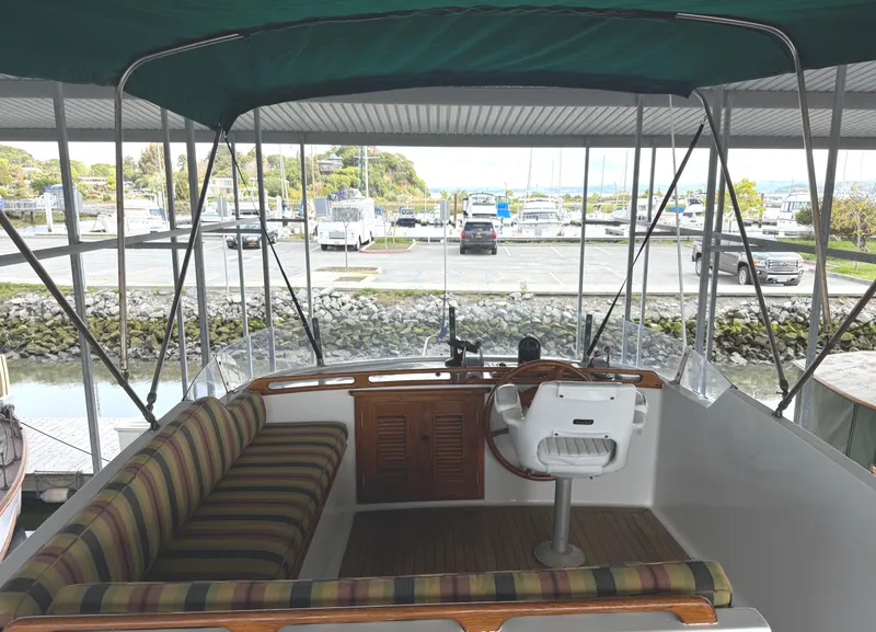 Slide: The Image of 1980 C & L Sea Ranger boat interior with striped seating and green canopy in marina. - 9