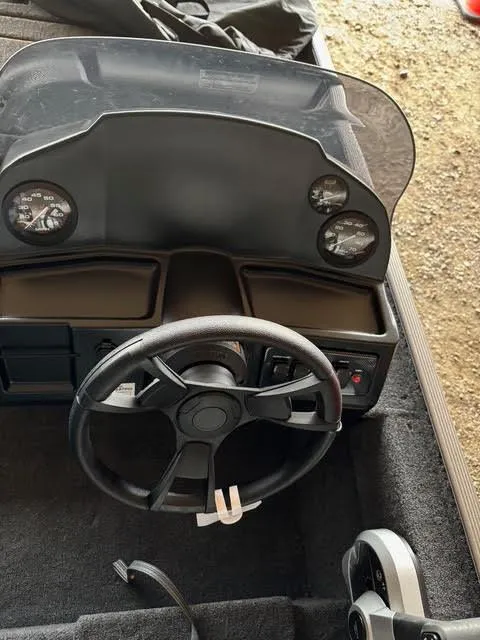 Slide: The Image of 2025 Lowe Skorpion 16 boat dashboard with steering wheel and gauges. - 16