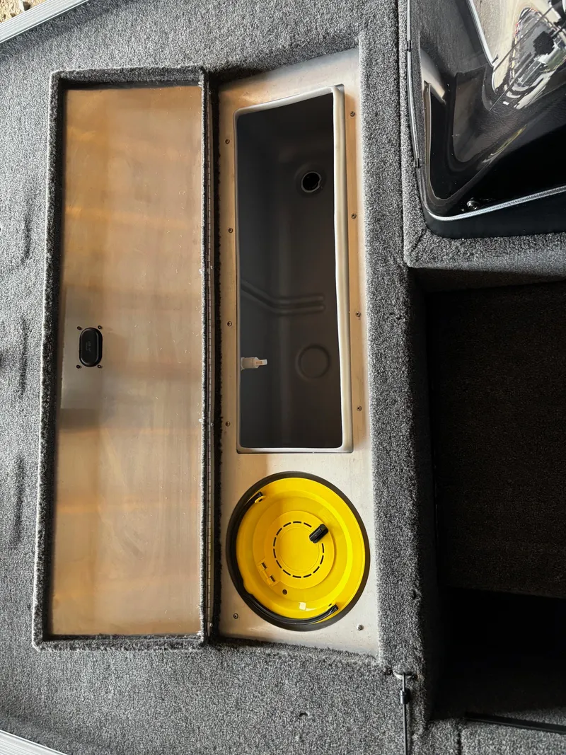 Slide: The Image of 2025 Lowe Skorpion 16 boat interior with storage compartments and yellow hatch. - 17