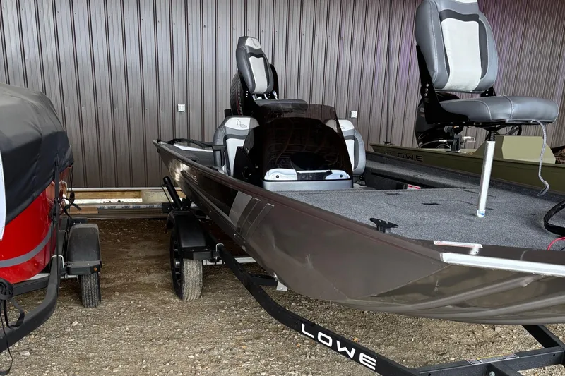 Slide: The Image of 2025 Lowe Skorpion 16 fishing boat on trailer, parked indoors. - 3