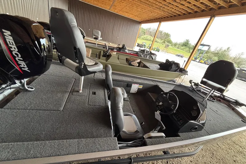 Slide: The Image of 2025 Lowe Skorpion 16 boat interior with seating and steering, under a wooden canopy. - 5