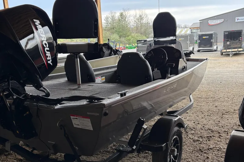 Slide: The Image of 2025 Lowe Skorpion 16 boat with Mercury engine, parked in a covered area. - 6