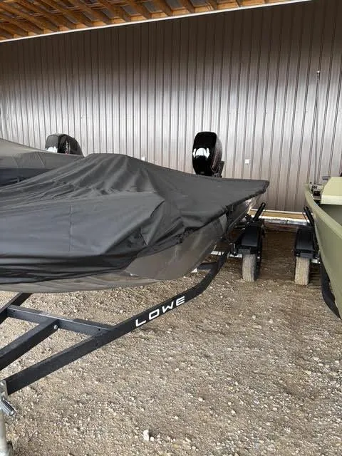 Slide: The Image of 2025 Lowe Skorpion 16 boat covered, parked on a trailer in a sheltered area. - 8