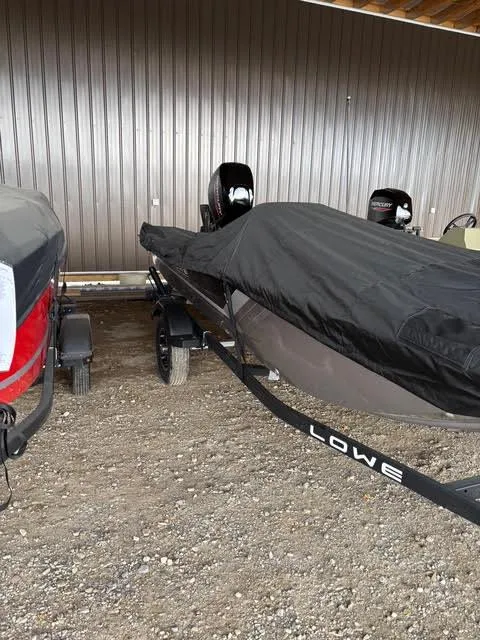 Slide: The Image of 2025 Lowe Skorpion 16 boat covered and parked on a trailer in a garage. - 9