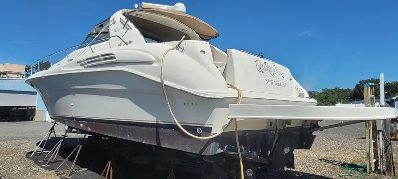 Slide: The Image of 1998 Sea Ray 450 Sundancer yacht on dry dock under clear blue sky. - 1