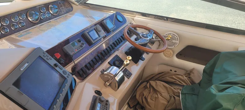 Slide: The Image of 1998 Sea Ray 450 Sundancer helm with navigation instruments and wooden steering wheel. - 12