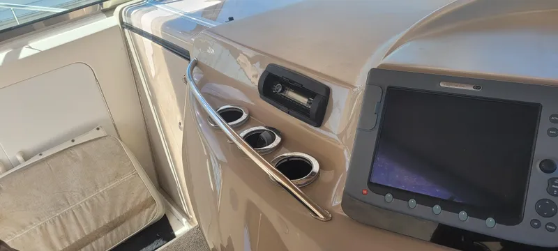 Slide: The Image of 1998 Sea Ray 450 Sundancer helm with navigation screen and cup holders. - 15