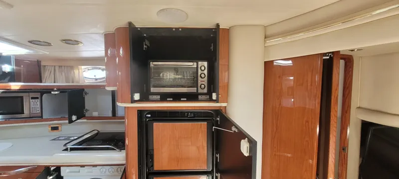 Slide: The Image of Interior of 1998 Sea Ray 450 Sundancer yacht with kitchen appliances and wooden cabinetry. - 17