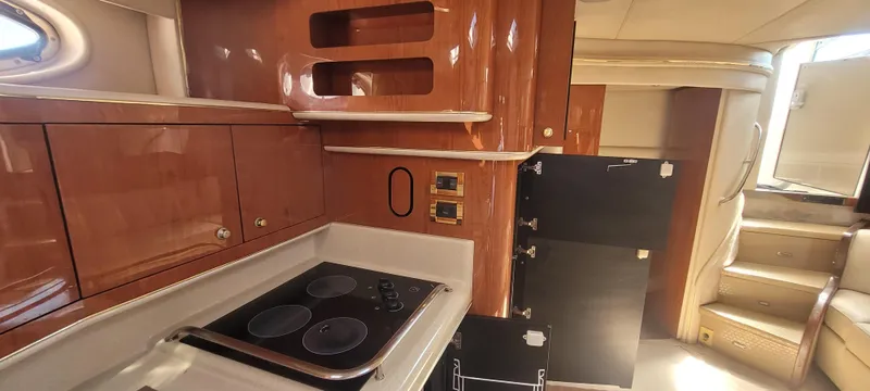 Slide: The Image of Interior of 1998 Sea Ray 450 Sundancer yacht, featuring a compact kitchen area. - 21