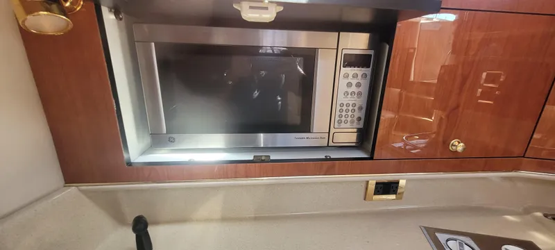 Slide: The Image of Microwave in 1998 Sea Ray 450 Sundancer yacht kitchen with wood cabinetry. - 23