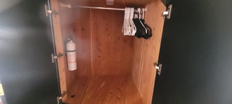 Slide: The Image of Wooden closet interior with hangers and fire extinguisher on a 1998 Sea Ray 450 Sundancer. - 26