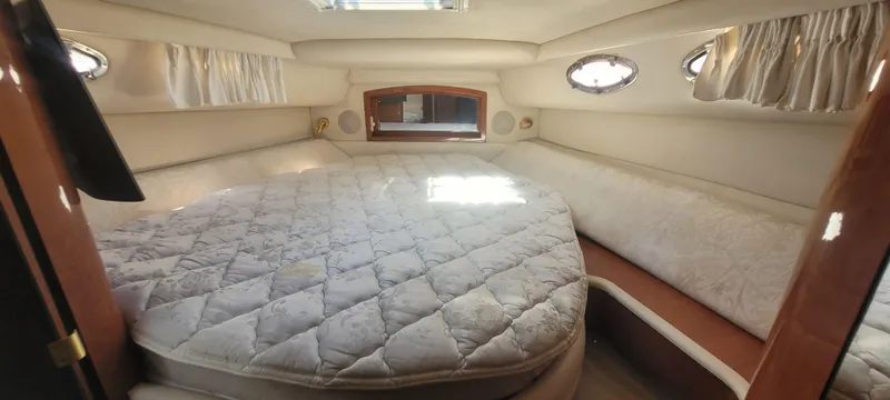 Slide: The Image of 1998 Sea Ray 450 Sundancer cabin with a spacious bed and elegant interior design. - 27