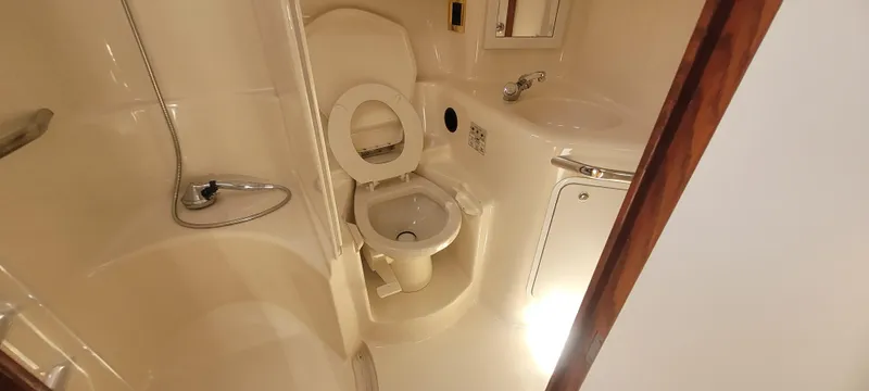 Slide: The Image of Bathroom interior of 1998 Sea Ray 450 Sundancer yacht, featuring toilet and shower. - 31