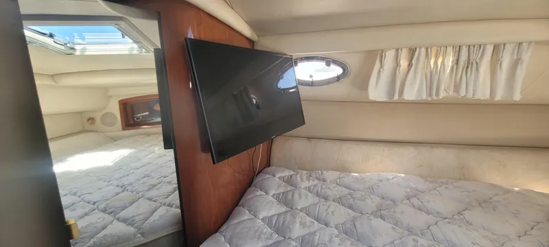 Slide: The Image of 1998 Sea Ray 450 Sundancer cabin with bed, TV, and porthole window. - 34