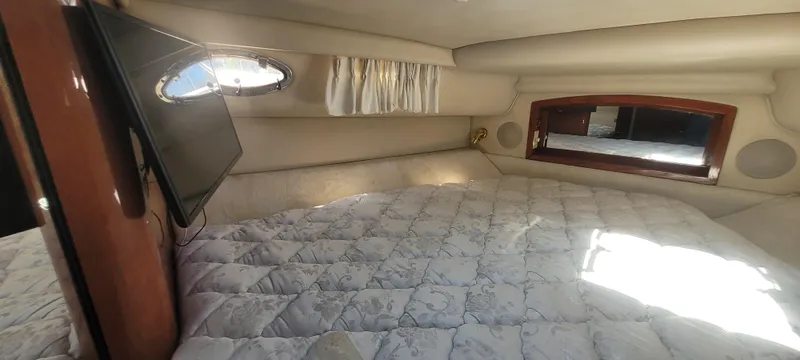 Slide: The Image of 1998 Sea Ray 450 Sundancer cabin interior with bed, window, and TV. - 36