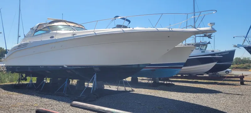 Slide: The Image of 1998 Sea Ray 450 Sundancer yacht on stands in a boatyard under clear blue sky. - 4