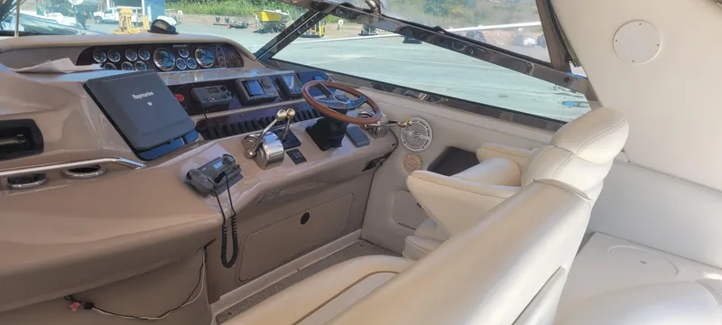 Slide: The Image of 1998 Sea Ray 450 Sundancer helm with beige interior and modern navigation equipment. - 40