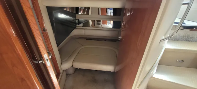 Slide: The Image of 1998 Sea Ray 450 Sundancer cabin interior with beige seating and wooden accents. - 44