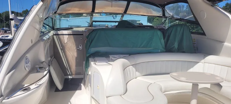 Slide: The Image of 1998 Sea Ray 450 Sundancer yacht interior with white seating and covered dashboard. - 7