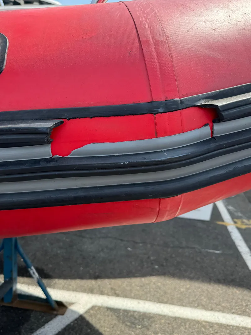 Slide: The Image of 2019 Zodiac Bayrunner 500 with visible damage on the red inflatable tube. - 13