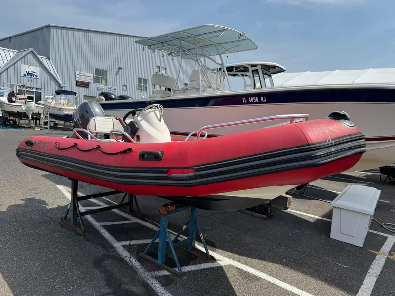 Slide: The Image of Red 2019 Zodiac Bayrunner 500 inflatable boat on stands in a marina parking lot. - 9