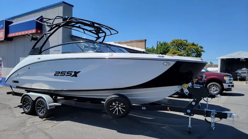 Slide: The Image of 2024 Yamaha Boats 255XD on trailer, sleek design, parked outdoors. - 0