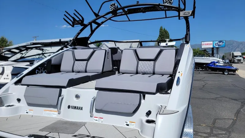 Slide: The Image of 2024 Yamaha Boats 255XD with sleek seating and modern design in a sunny outdoor setting. - 1