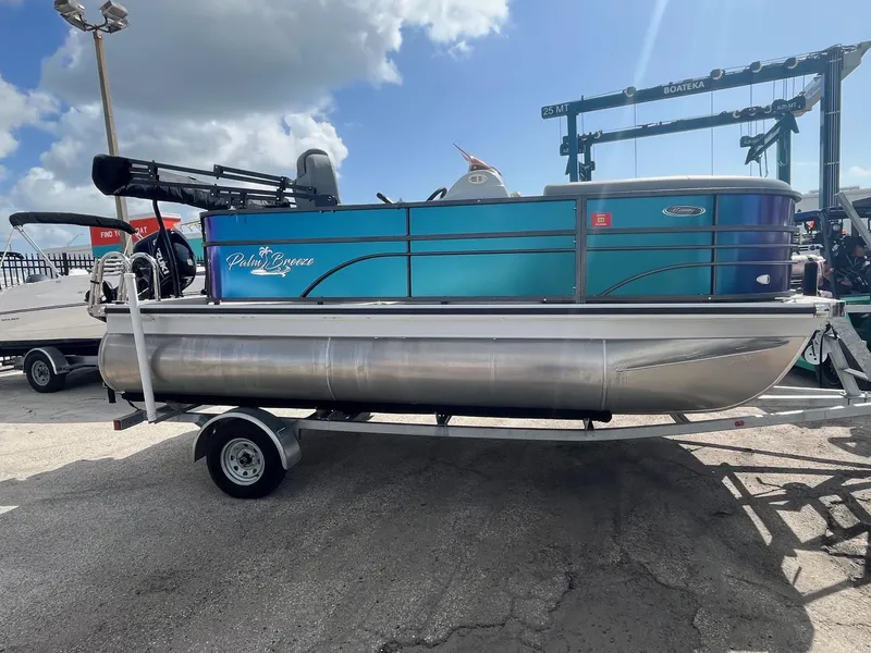 The Image of 2024 Lexington 17 Emerg pontoon boat on trailer under a cloudy sky. - 0