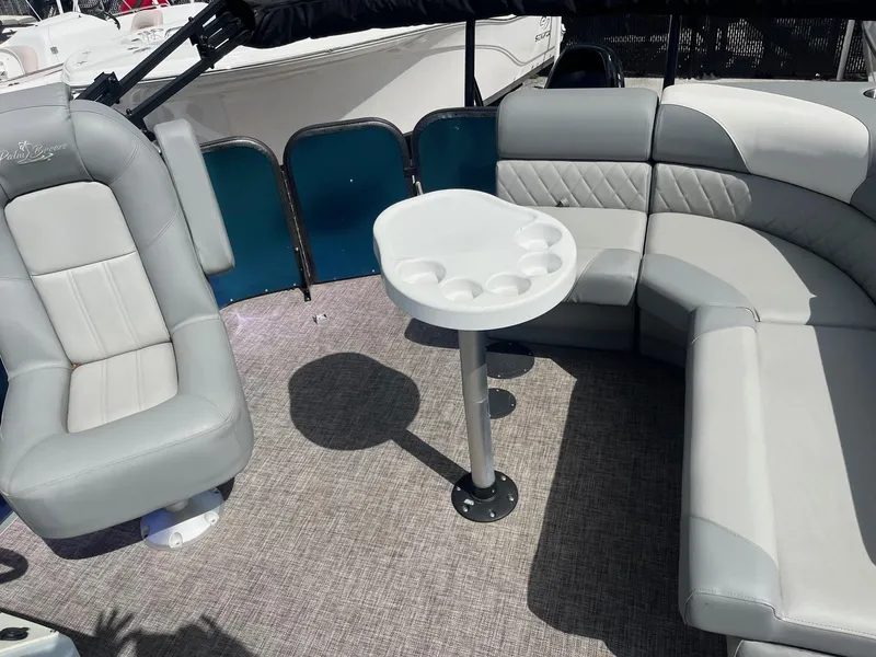 Slide: The Image of 2024 Lexington 17 Emerg boat interior with gray seating and a round table. - 5