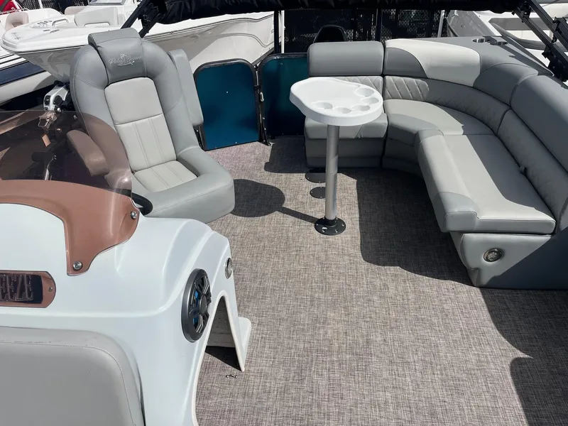Slide: The Image of 2024 Lexington 17 Emerg boat interior with gray seating and round table. - 6