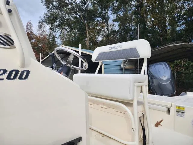 Slide: The Image of 2024 Pathfinder 2200 TRS boat interior with steering wheel and seating, outdoors. - 13