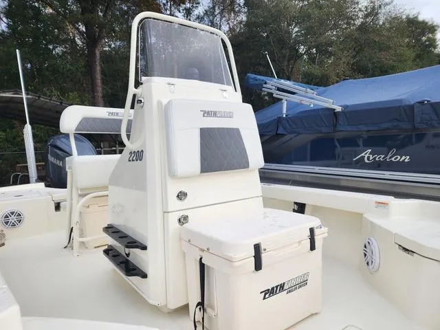 Slide: The Image of 2024 Pathfinder 2200 TRS boat interior with console and seating, featuring a cooler and storage. - 17