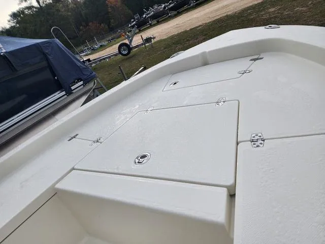 Slide: The Image of 2024 Pathfinder 2200 TRS boat deck with storage compartments, parked outdoors. - 18