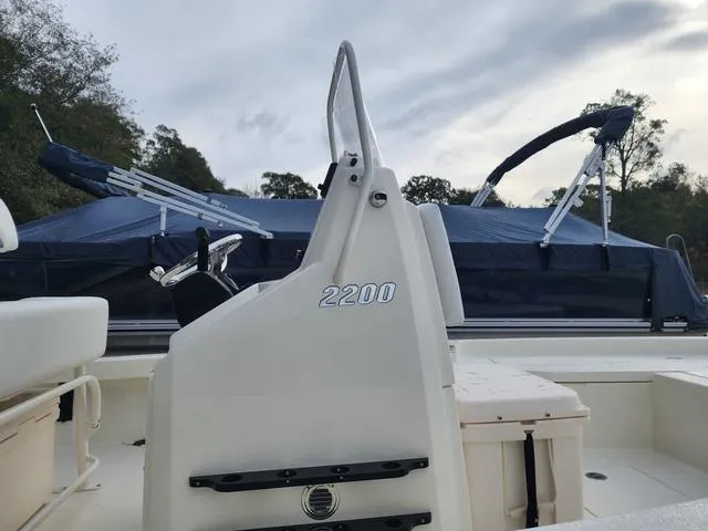 Slide: The Image of 2024 Pathfinder 2200 TRS boat with console and seating, under a cloudy sky. - 22