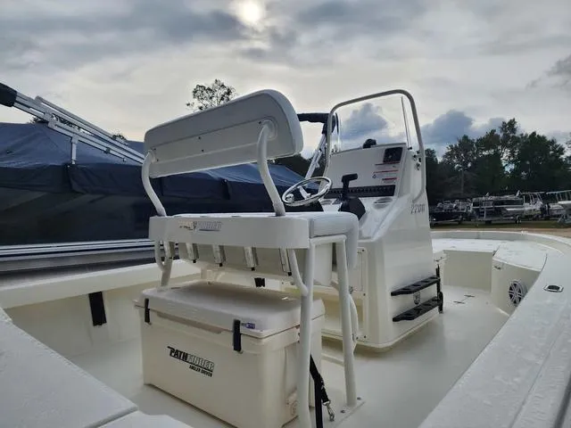 Slide: The Image of 2024 Pathfinder 2200 TRS boat interior with console and seating, under a cloudy sky. - 24