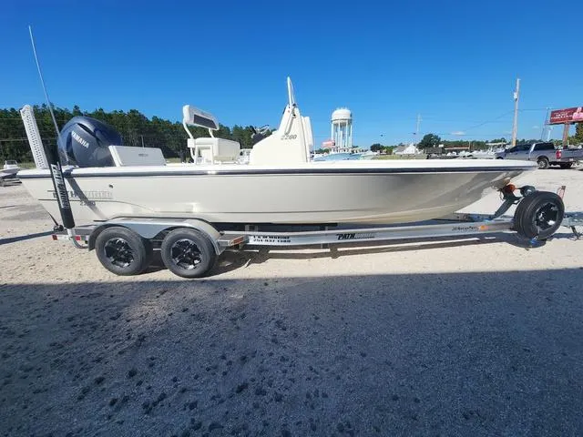 Slide: The Image of 2024 Pathfinder 2200 TRS boat on trailer, side view, outdoors under clear blue sky. - 3
