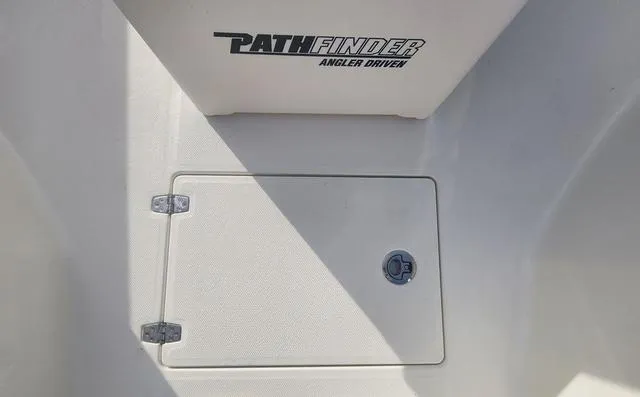 Slide: The Image of 2024 Pathfinder 2200 TRS boat interior with storage compartment and logo. - 39