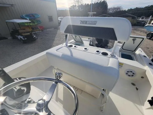 Slide: The Image of 2024 Pathfinder 2200 TRS boat interior with steering wheel and seating, parked outdoors. - 41