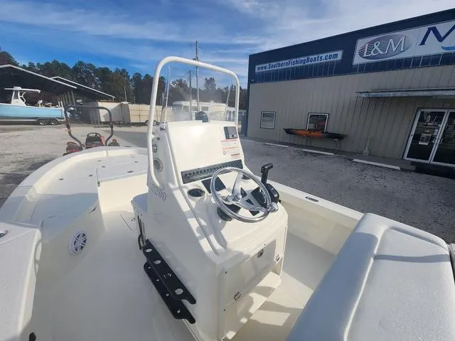Slide: The Image of 2024 Pathfinder 2200 TRS boat at dealership, featuring steering console and spacious deck. - 48