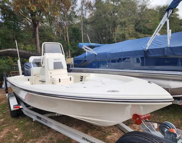 Slide: The Image of 2024 Pathfinder 2200 TRS boat on trailer, parked outdoors near covered boats. - 7