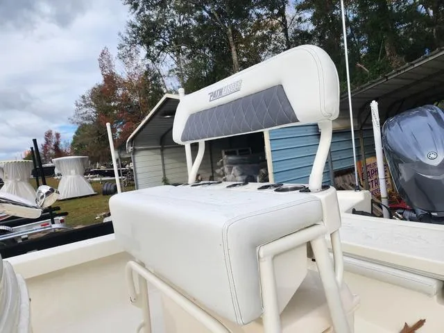 Slide: The Image of 2024 Pathfinder 2200 TRS boat seat with storage, outdoors near a shed. - 9