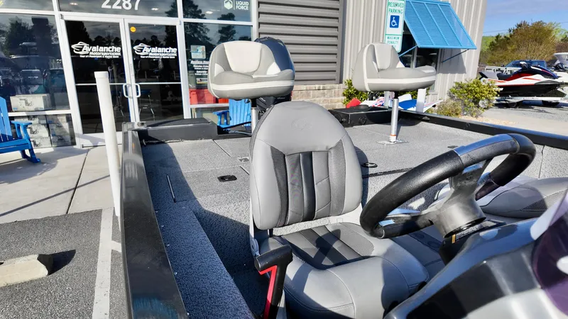 Slide: The Image of 2021 G3 Sportsman 1610 boat interior with seating and steering wheel, outside a dealership. - 7