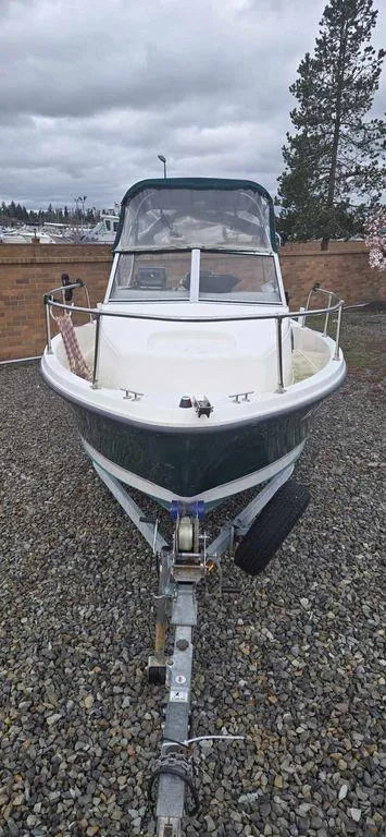 Slide: The Image of 2006 Bayliner Trophy 1802 WA boat on trailer, parked on gravel, cloudy sky background. - 8