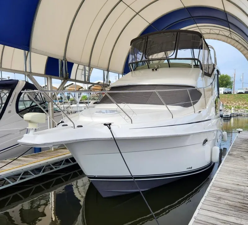 Slide: The Image of 2005 Silverton 35 Motor Yacht docked under a canopy at a marina. - 0