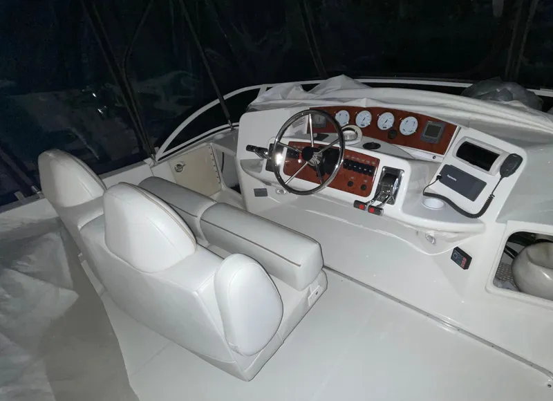 Slide: The Image of 2005 Silverton 35 Motor Yacht helm with white seating and control panel. - 12